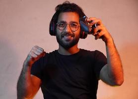yong man with playing game's Joystick and wearing headphone photo