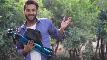 the photographer with tripod. Young man taking photo with his camera