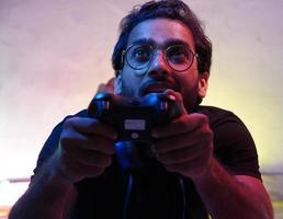 exited man using playing video game using gaming wireless joystick- gaming concept photo