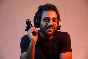 yong man with playing game's Joystick and wearing headphone photo