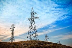 torres de transmisión de electricidad en la colina durante la hermosa puesta de sol. foto