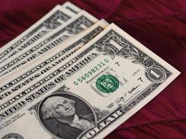 One Dollar notes, United States over red velvet background photo