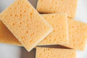 Yellow porous sponges on a white background photo