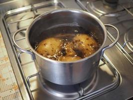 Boiling potato in saucepan photo