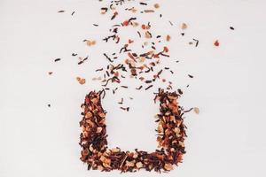 Dry fruit tea randomly scattered on a white table background. Top view. Copy, empty space for text photo