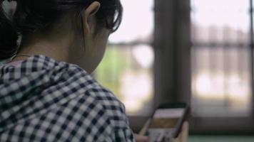 adolescente regardant un fichier de clip vidéo à partir d'un site Web sur un smartphone mobile.