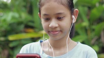 Portrait happy teenage girl watching social video online on mobile smartphone.