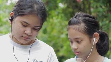 Portrait of two teenage girl watching social video online on mobile smartphone.