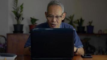 homme d'affaires senior parlant à un employé de l'entreprise avec vidéoconférence sur ordinateur portable à la maison. video