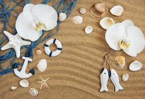 sea shells with sand and orchid flowers photo