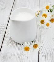 jug with milk  and chamomile flower photo