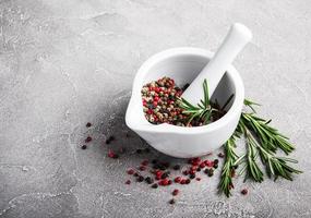 Pepper in white mortar and rosemary photo