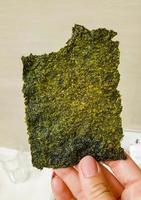 Thai seaweed snack unpacked hold in the hand in Thailand. photo