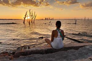 Woman contemplating the sunset in front of the sea. photo