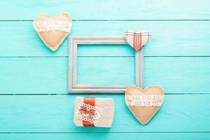 Romantic frame with copy space and accessories on blue wooden background. Top view photo