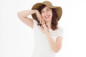 mujer feliz en sombrero de verano aislado sobre fondo blanco. protección solar, cuidado de la piel y concepto de vacaciones. mujer de mediana edad con dientes blancos sanos y menopausia. viaje de vacaciones. copie el espacio foto