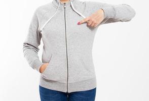 Woman pointed on empty hoodie sweater on light background. Space for design photo