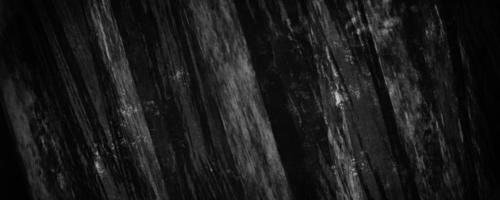 black concrete cement grainy and defocused background with dark gray cracks and crumpled wrinkles photo