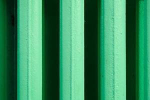 abstract vertical stripes pattern from an old home heating battery made of cast iron and painted in green photo