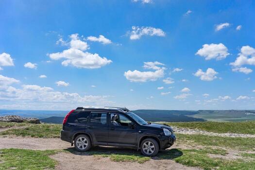 Belogorsk, Crimea-may 22, 2018 - Black SUV on a natural landscape background photo