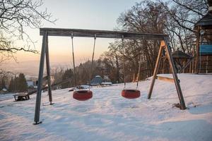 Children's Playground in winter evening in Austria. photo