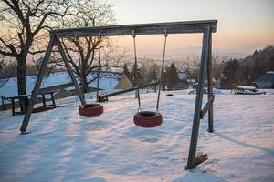 Children's Playground in winter evening in Austria. photo