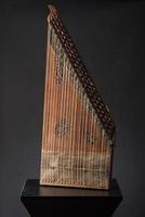 ancient Asian stringed musical instrument on black background with backlight. the similarity of the harp and psaltery photo