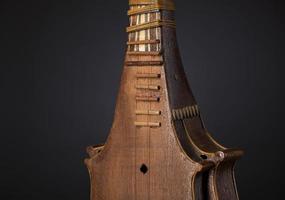 part ancient Asian stringed musical instrument on black background with backlight photo