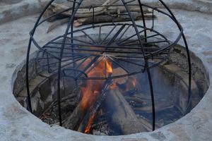 in the pit a construction of metal rods for smoke. metal structure for cooking on fire photo