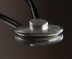 medical stethoscope on mirror background with reflection. isolated, close-up photo