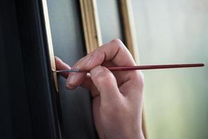 painter decorator draws pattern with a thin brush photo