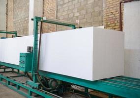 The machine cuts foam plastic. Plant for the production of sandwich panels from styrofoam photo