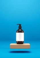 The pump bottle on floating beige platform on blue backdrop, Minimalist background for spa and cosmetic presentation. 3d rendering photo