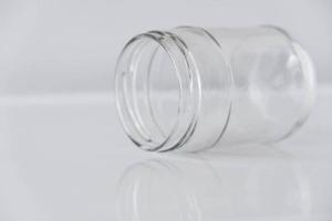 Empty glass transparent jar on a white table photo