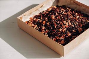 Dry fruit tea in a paper box on a white table background. Copy, empty space for text photo