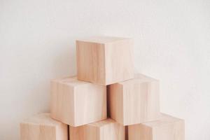 Pyramid of wooden blocks from natural wood on a white background. Copy, empty space for text photo