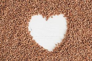 Buckwheat as a heart background texture on a white background photo