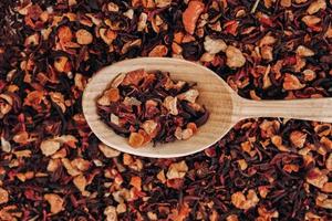 Dry fruit tea in a wooden spoon as a background texture. Top view. Copy, empty space for text photo