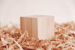 One wooden block on a background of carpentry shavings. Copy, empty space for text photo
