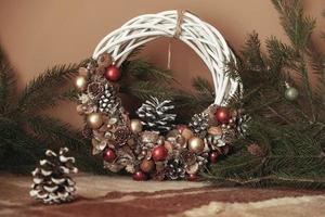 Christmas wreath of vines decorated with fir branches, Christmas balls and natural materials photo