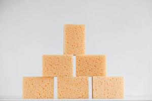 Yellow porous sponges on a white background photo