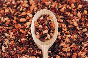 Dry fruit tea in a wooden spoon as a background texture. Top view. Copy, empty space for text photo