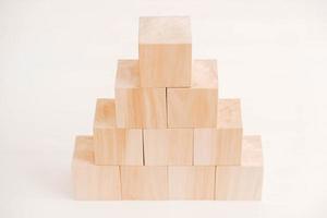 Pyramid of wooden blocks from natural wood on a white background. Copy, empty space for text photo