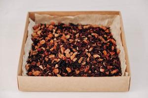 Dry fruit tea in a paper box on a white table background. Copy, empty space for text photo