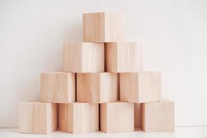 Pyramid of wooden blocks from natural wood on a white background. Copy, empty space for text photo