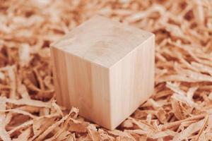 One wooden block on a background of carpentry shavings. Copy, empty space for text photo