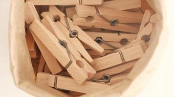 Many wooden clothespins on a white table background photo