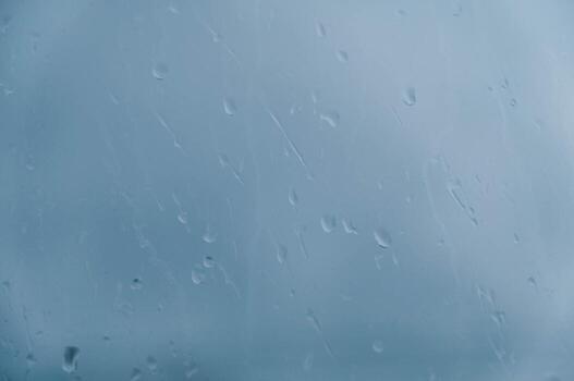 Drops of water run down the glass that is fogged with a blurred background. Copy, empty space for text photo