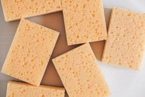 Yellow porous sponges on a white background photo