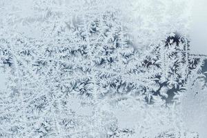 Ice patterns on frozen glass. Abstract ice pattern on winter glass as a background image photo